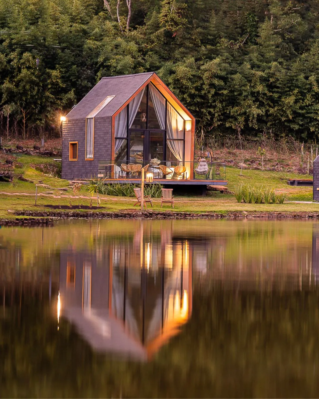 Lake house iluminada refletida no lago ao anoitecer